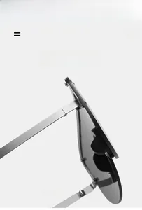 Détail de lunettes de soleil oversize montrant les branches en métal argenté et la charnière