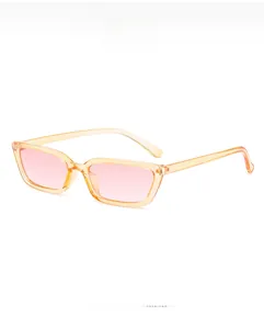 Détail de lunettes de soleil rétro avec monture orange thé et verres roses de style Y2K
