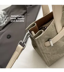 Detail of silver metal lobster clasp on durable beige canvas tote bag with shoulder strap