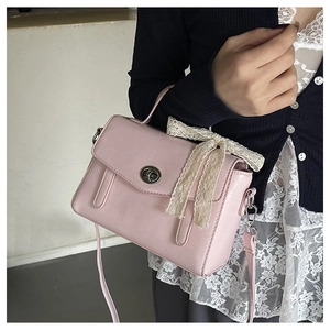 Détail du sac rose avec nœud en dentelle et fermoir rotatif circulaire élégant pour femme