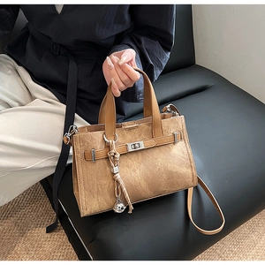 Detail view of vintage brown tote with textured faux leather and metal buckle closure