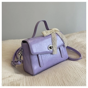 Détail d'un sac cabas violet plissé avec nœud en dentelle et fermoir rotatif argenté