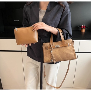Detail of vintage brown leather tote bag with silver buckle and matching small pouch