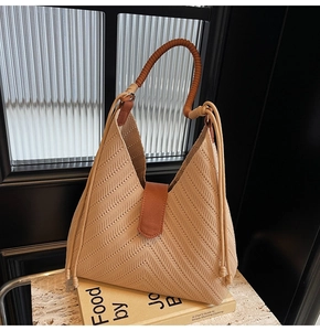 Close-up of woven tote bag with herringbone texture and contrast brown rope handles