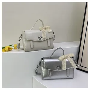 Détail de sacs carrés en PU rétro beige et argent avec nœuds en dentelle et fermoirs