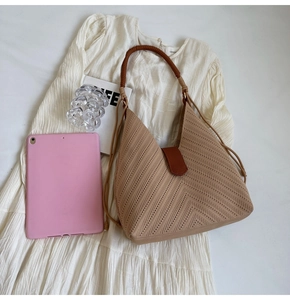 Detailed top view of a woven tote bag showing beige herringbone pattern and brown handles