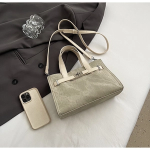 Detail of canvas tote bag with silver metal twist lock and contrasting straps
