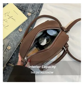 Internal capacity of the brown retro crossbody bag showing cosmetics and interior space