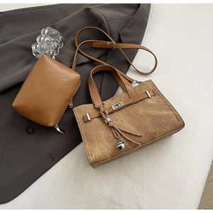 Detail of vintage brown tote bag set with metal clasp and small leather zipper pouch