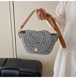 Détail du sac tissé avec motif géométrique noir et blanc et fermoir perle élégant