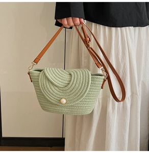 Détail du sac seau vert tissé main avec fermoir perle et bandoulières en cuir