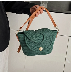 Détail d'un sac tressé vert avec fermoir perle et poignée en cuir marron