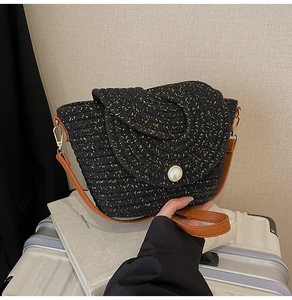 Détail du sac à bandoulière tressé noir avec boucle de perle et sangle en cuir marron