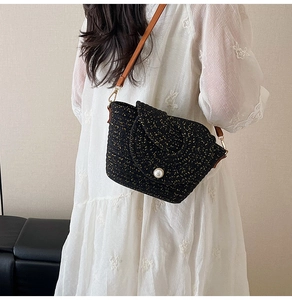 Détail du sac bandoulière en tweed noir tissé main avec boucle perle et bandoulière cuir