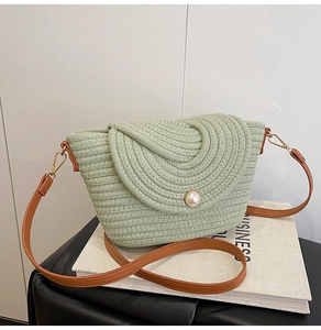 Détail du sac bandoulière tissé vert avec fermoir perle et bandoulière en cuir marron