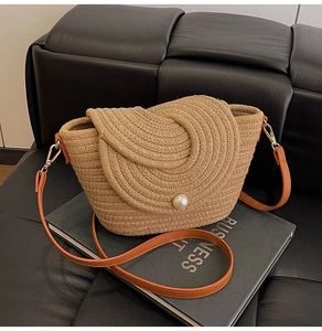 Texture détaillée du sac en paille tissée avec fil métallique et fermoir à perle