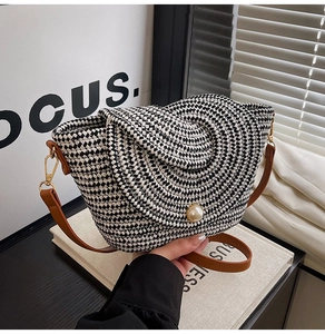 Détail d'un sac bandoulière tissé à la main avec fermoir perle et bandoulière en cuir brun
