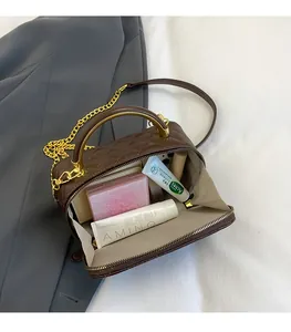 Detailed interior of a brown quilted leather crossbody bag with chain strap and gold handle