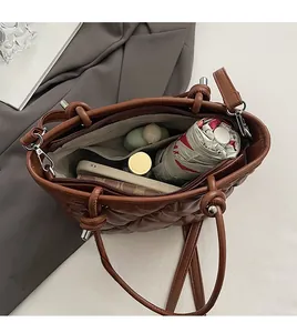 Internal view of brown quilted tote bag showing main compartment and zippered pocket