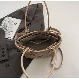 Detail view of beige quilted tote bag interior showing dark brown lining and zipper pocket