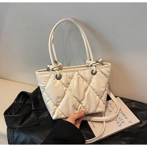 Detail of creamy white puffy quilted tote bag showing soft texture and stitching