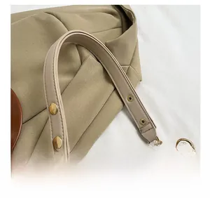 Detail of comfortable shoulder strap with gold rivets on striped woven bag
