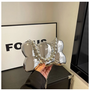 Dettaglio ravvicinato di una borsa da sera in acrilico argento a forma di fiocco lucido