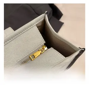 Detailed close-up of premium golden zipper hardware and brown herringbone fabric lining