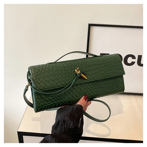 Detail of dark green woven leather texture and gold knot-shaped metallic buckle