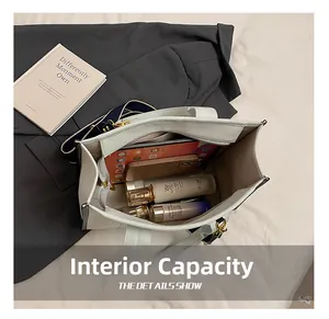 Detail view of the spacious interior of this white faux leather tote with inner pockets