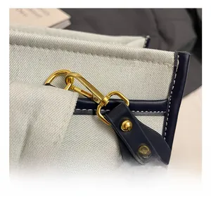 Detail of premium golden metal hook and blue leather strap on canvas tote bag