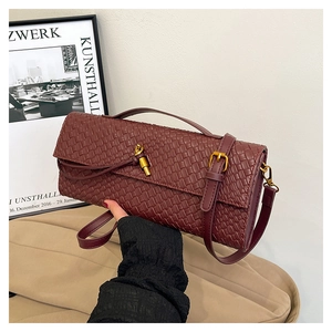 Close-up of wine red woven baguette bag featuring intricate texture and gold metal clasp