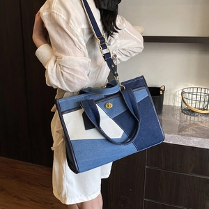 Detail of multi-color patchwork denim tote bag with gold twist lock and webbing handles