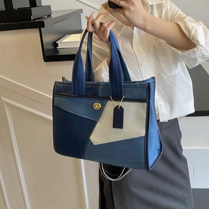 Detail of multi-color patchwork denim tote bag with gold twist lock and sturdy handles