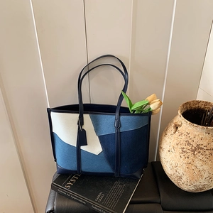 Détail du sac fourre-tout avec patchwork bleu et blanc sur des livres d'art