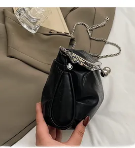 Detailed shot of black pleated evening bag with silver chain and metal clasp closure