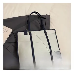 Détail du grand sac cabas en toile avec bordure en cuir bleu et clous de protection en métal