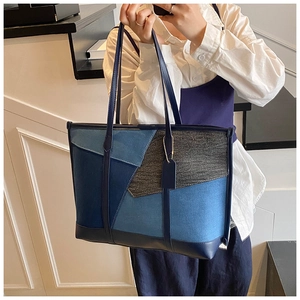 Détail du cabas en jean avec empiècements en cuir et fine bandoulière élégante
