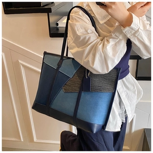 Détail du sac fourre-tout en patchwork de denim bleu avec anses en cuir bleu foncé
