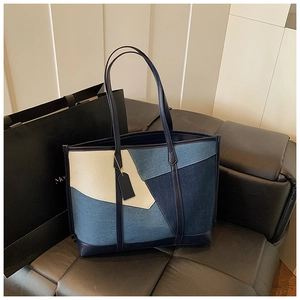 Détail du sac fourre-tout en denim avec un design patchwork bleu et coutures précises