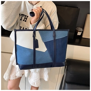 Détail du cabas en denim color-block montrant les panneaux patchwork et les anses