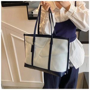 Détail du sac cabas grande capacité bicolore avec bandoulière présenté par un mannequin