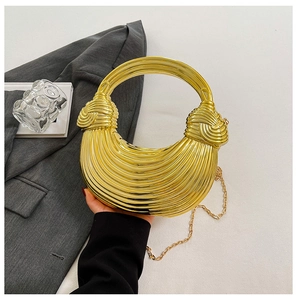 Close-up of golden shell evening bag with textured surface and chain strap detail