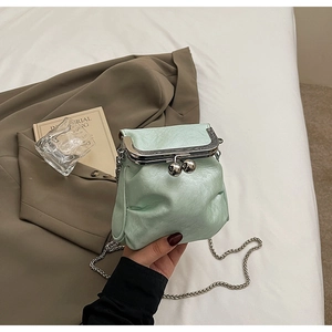Close-up of mint green vintage kiss-lock bag with pleated texture and silver chain