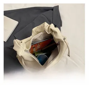 Top view of cream white pleated hobo bag showing spacious interior for tablet and cosmetics