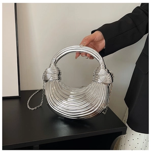 Detail of silver metallic pleated half-moon bag with circular handle and chain strap