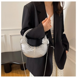 Detail of silver metallic crescent bag with striped texture and elegant chain strap