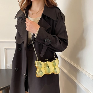 Elegante borsa a farfalla dorata metallizzata con catenina sottile indossata da modella