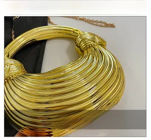 Detailed view of the textured golden acrylic shell bag with metallic horizontal ridges