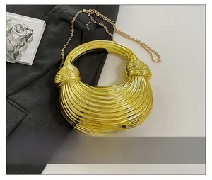 Close-up of gold pleated shell bag with round handle and elegant chain strap detail